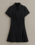 Schwarzes kurzes Hemdblusenkleid mit Knopfleiste und ausgestelltem Rock flach ausgelegt auf hellem Untergrund.