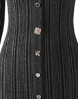 Nahaufnahme des schwarzen Strickkleids mit sichtbarer Rippenstruktur und metallischen Knöpfen im Fokus.