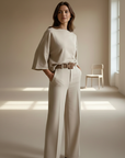 Female model in a beige two-piece matching set featuring a relaxed sweater and wide-leg trousers.