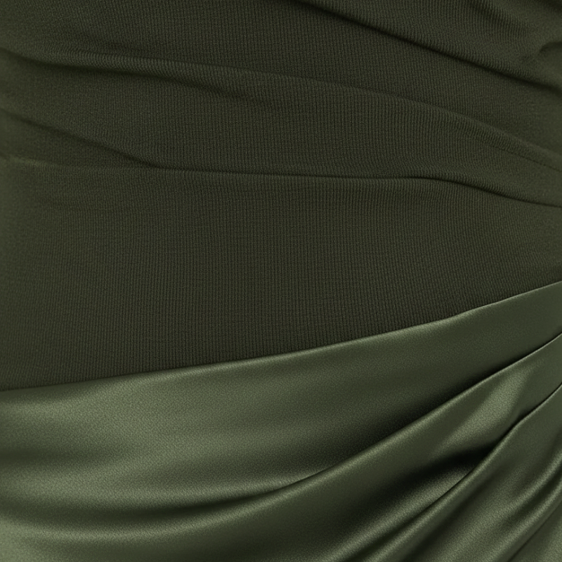 Nahaufnahme des olivgrünen Kleids mit glattem Stoff und kunstvoll drapierter Textur.