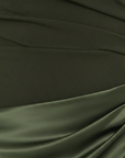Nahaufnahme des olivgrünen Kleids mit glattem Stoff und kunstvoll drapierter Textur.
