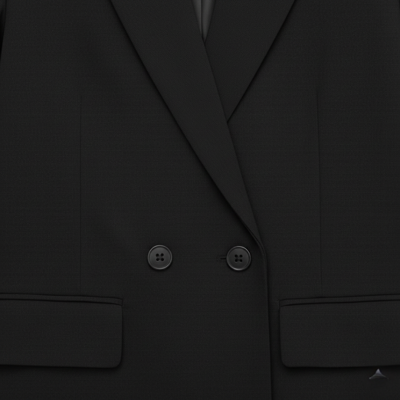 Nahaufnahme eines schwarzen Blazers mit strukturiertem Stoff, präzisem Revers und fein gearbeiteter Knopfverarbeitung.