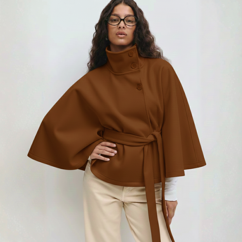 Braunes Cape-Oberteil mit weitem Schnitt und Bindegürtel, kombiniert mit heller Hose in Studioaufnahme.
