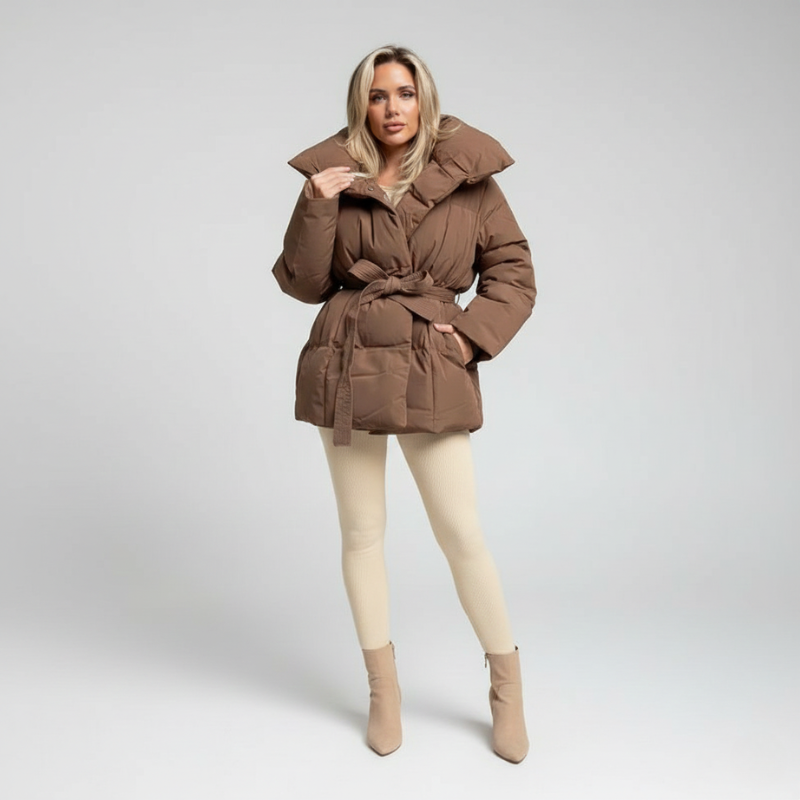 Ganzkörperansicht einer braunen Daunenjacke mit figurbetonter Passform vor neutralem Studiohintergrund.