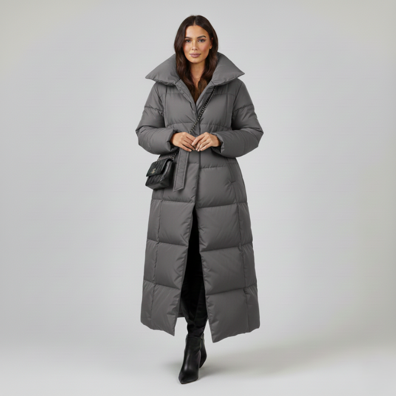 Grauer gesteppter Wintermantel mit hohem Kragen und Gürtel, getragen in einer neutralen Studioaufnahme.