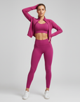 Pinkes Sportset aus Crop-Top und Leggings, getragen von einem Model in einem sonnenhellen Innenraum.