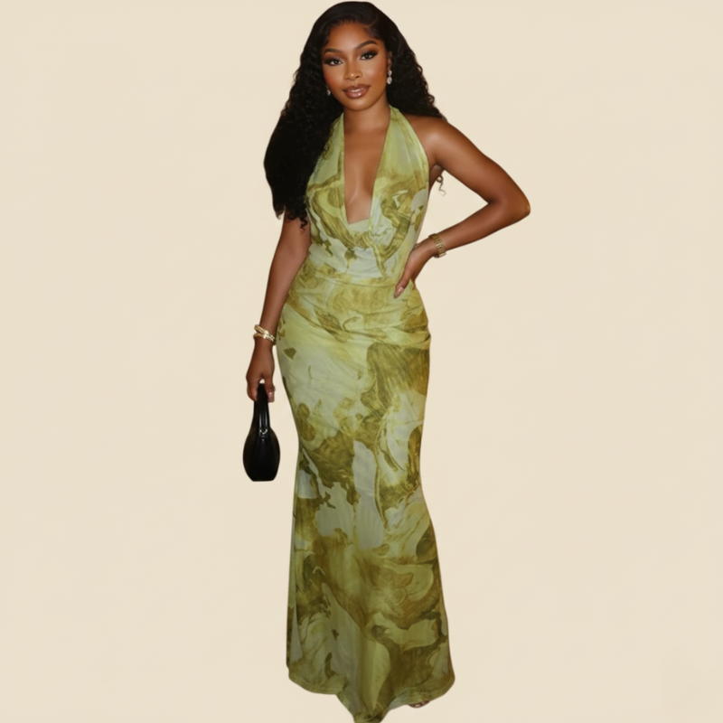 Model trägt ein grünes florales Maxikleid mit tiefem Ausschnitt und figurbetonter Form in einem minimalistischen Studio.