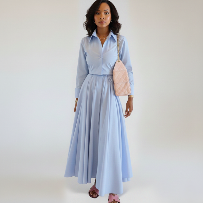 Model präsentiert ein hellblaues Maxikleid mit kurzem Ärmel, Knopfleiste und fließendem Stoff im Studio.