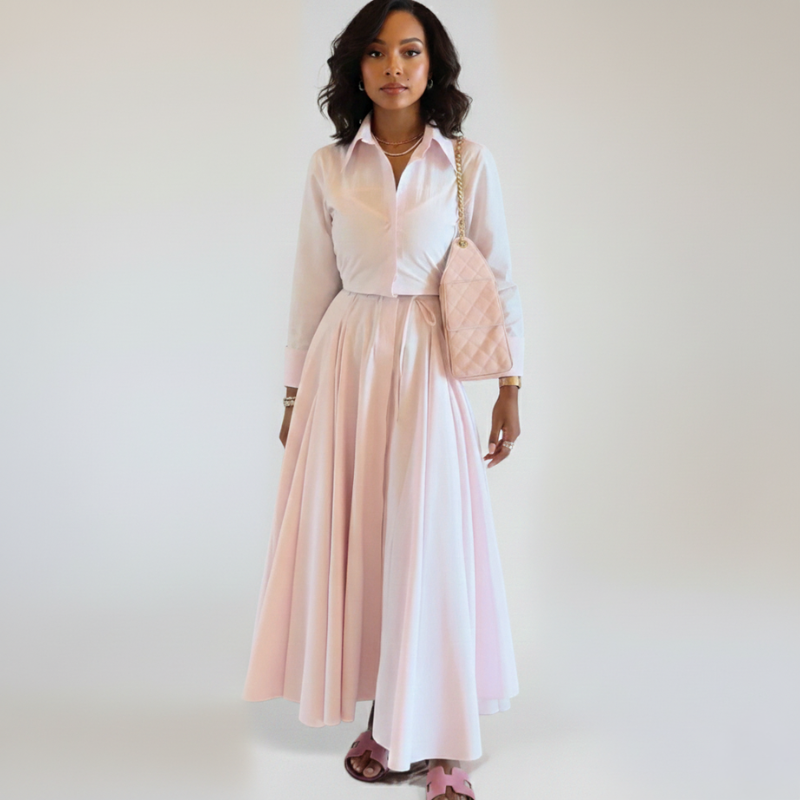 Model trägt ein rosafarbenes Maxikleid mit kurzärmeliger Silhouette, Kragen und fließendem Stoff im Studio.