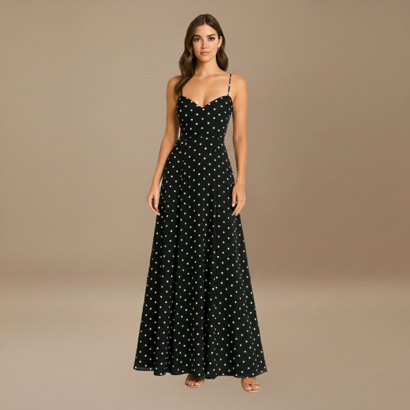 Schwarzes Maxikleid mit weißen Punkten, feinen Trägern und eleganter Silhouette, präsentiert im neutralen Studio.