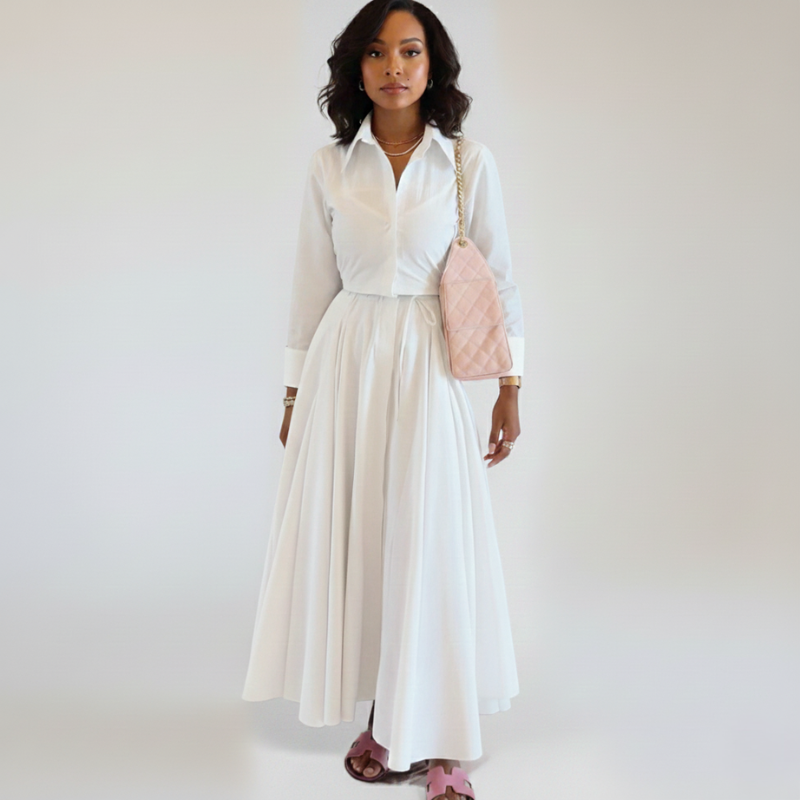 Model trägt ein weißes Maxikleid mit Kragen, Knopfleiste und leicht ausgestelltem Rock in heller Umgebung.