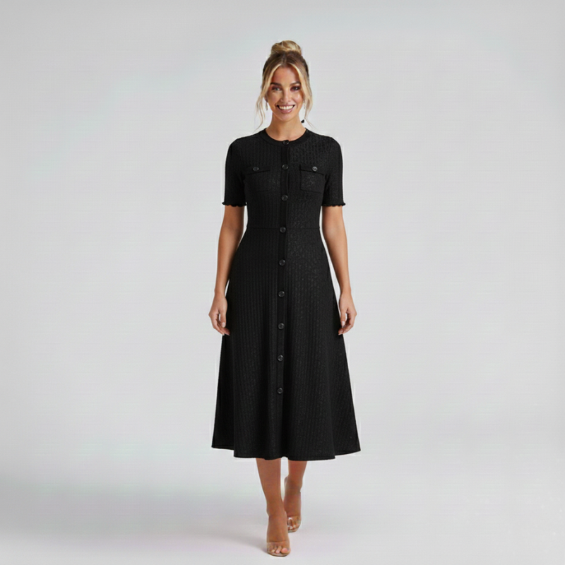 Model trägt ein schwarzes Damen-Midikleid mit kurzen Ärmeln und ausgestelltem Rock in einer neutralen Studioaufnahme.