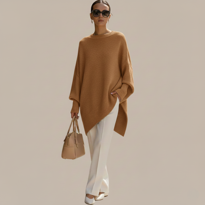 Frau trägt ein beigefarbenes Oberteil mit lockerer Silhouette, kombiniert mit weißer Hose im Studio.