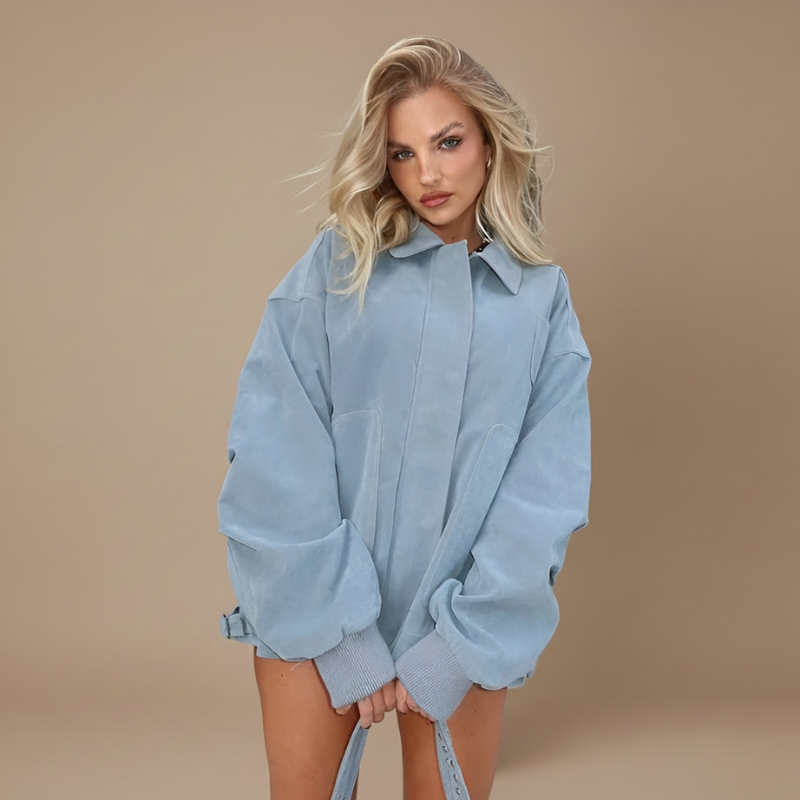 Model trägt ein hellblaues Oversize-Sweatshirt mit weitem Schnitt, hohem Kragen und weicher Textur vor neutralem Hintergrund.