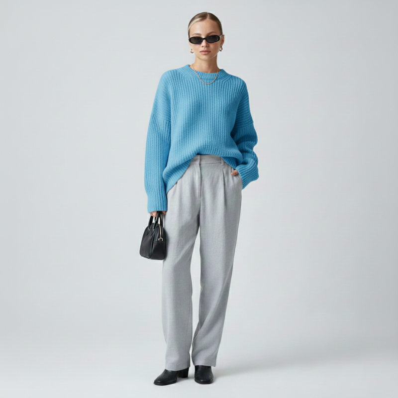 Hellblauer Oversize-Pullover mit weicher Textur und weiter Silhouette in einer klaren, hellen Studioszene.
