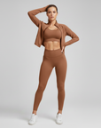 Braunes zweiteiliges Sportset mit modernem Crop-Top und schlanker Leggings, präsentiert im Studio.