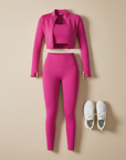 Pinkes zweiteiliges Sportset bestehend aus Crop-Top und Leggings flach ausgelegt auf hellem Hintergrund, kombiniert mit Sneakers.