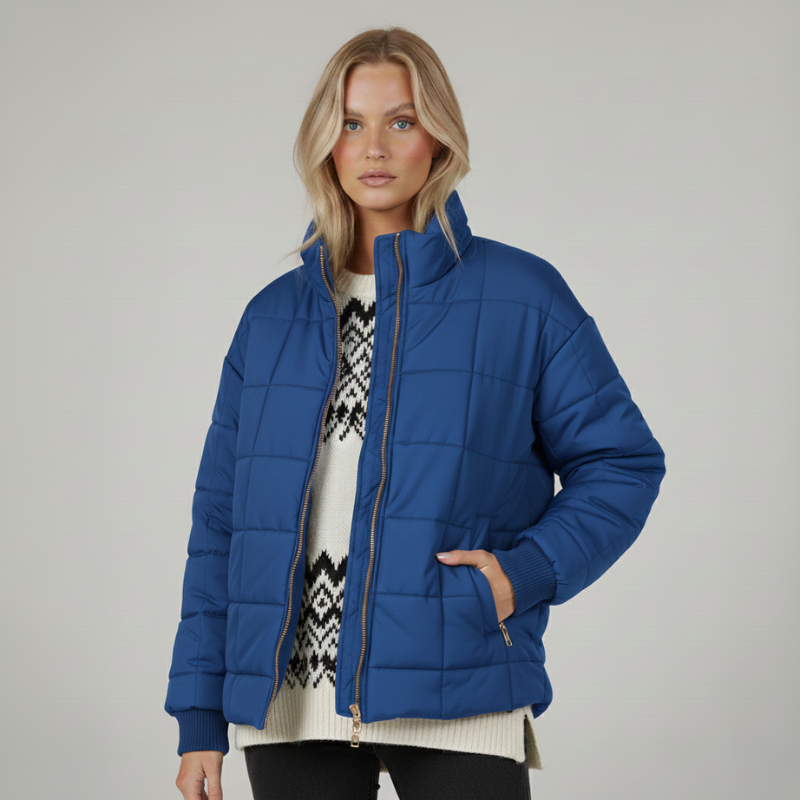 Blaue Steppjacke mit Reißverschluss, seitlichen Taschen und moderner Passform, getragen im Studio.