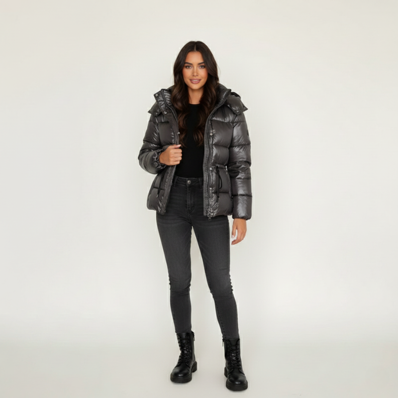 Model trägt eine braune Steppjacke mit strukturierter Oberfläche und Reißverschluss im neutralen Studio.