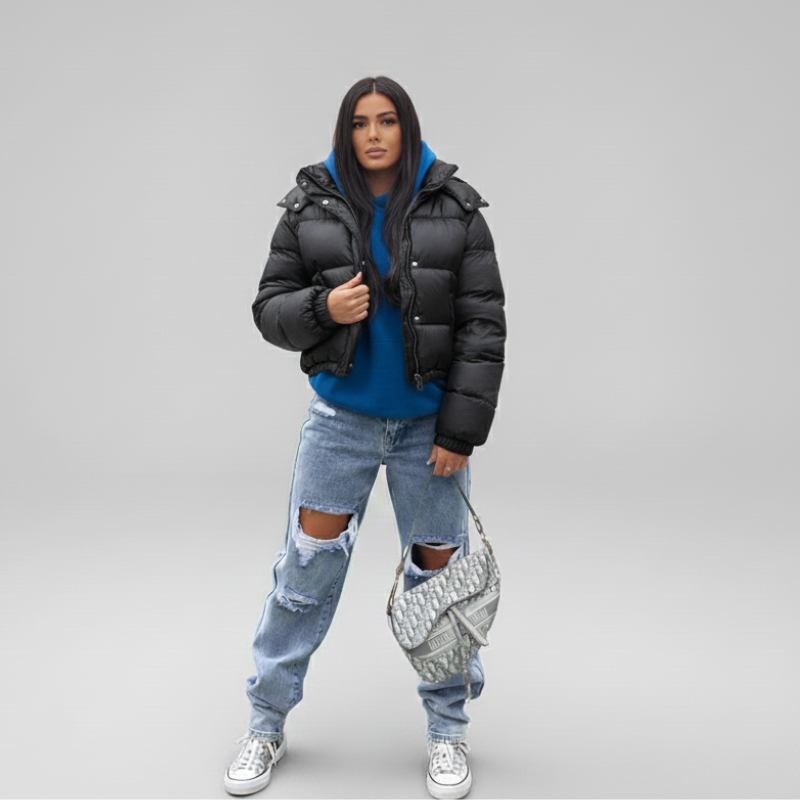 Model trägt eine weiße Steppjacke mit Kapuze und sportlicher Silhouette in heller Studioatmosphäre.