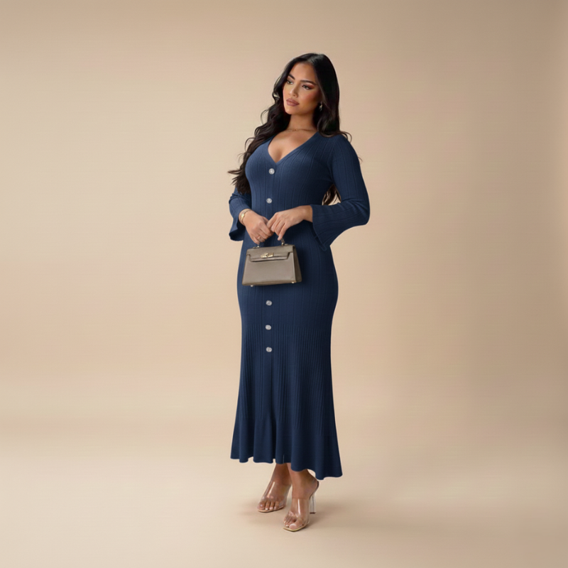 Model trägt ein navyblaues Strickkleid mit V-Ausschnitt, Knopfleiste und femininer Silhouette vor neutralem Hintergrund.