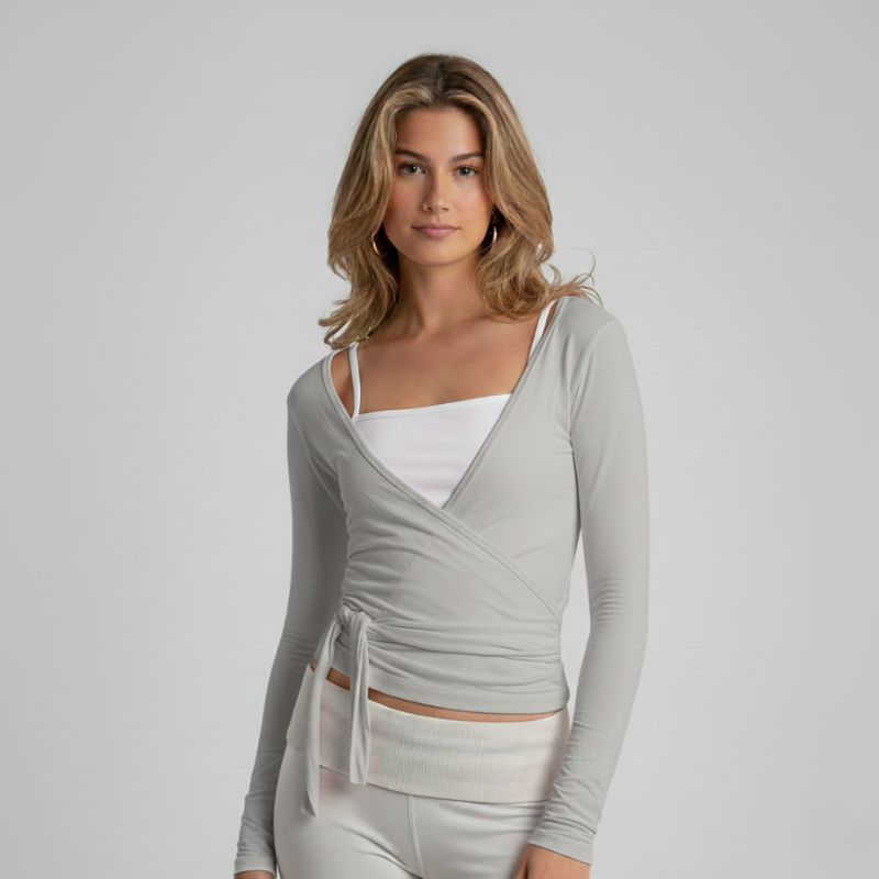 Graues Wickeltop mit Wickeloptik und schlanker Silhouette in einer klaren Studioaufnahme.