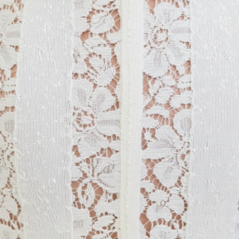 Nahaufnahme der floralen Spitzenstruktur des weißen Maxikleids