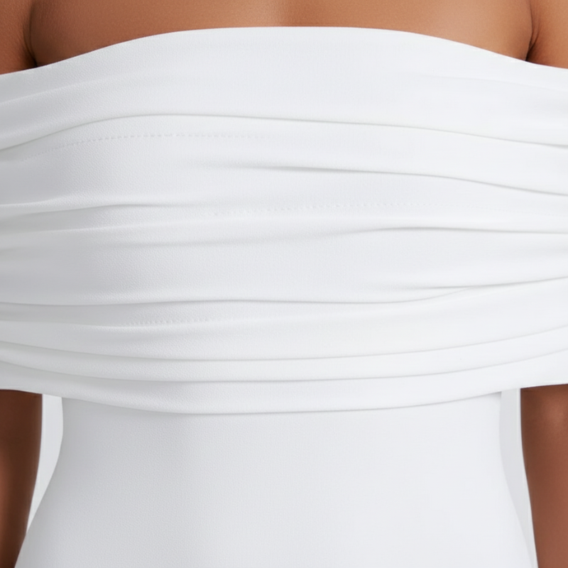 Nahaufnahme des schulterfreien Ausschnitts und der Stoffstruktur des weißen Maxikleids