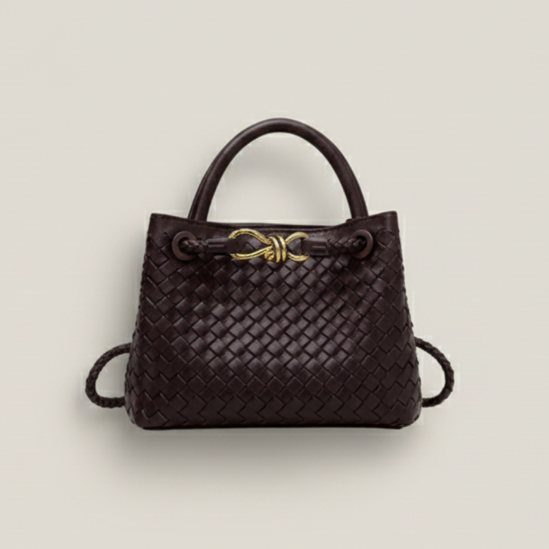 Dunkelbraune, geflochtene Handtasche mit goldener Metallschließe auf hellem Hintergrund, klar und hochwertig präsentiert.