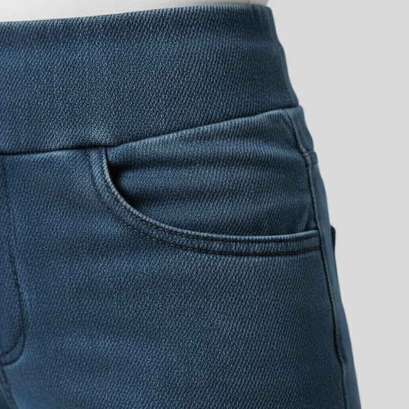 Nahaufnahme des Bundes und der Tasche der blauen Damen-Jeanshose mit feiner Textur.