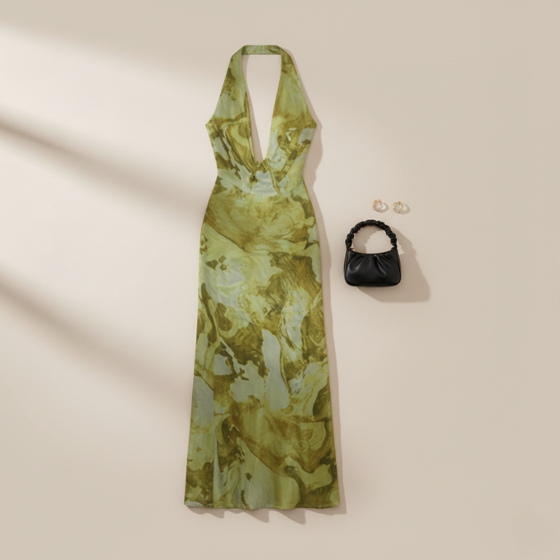 Grünes Maxikleid mit floralem Muster und tiefem Ausschnitt auf einem Kleiderbügel vor neutralem Hintergrund gezeigt.