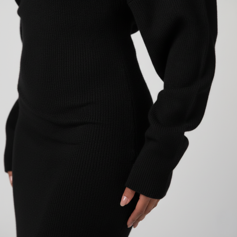 Nahaufnahme des schwarzen Kleids mit weichem Stofffall und dezent strukturierter Oberfläche am Ärmel.