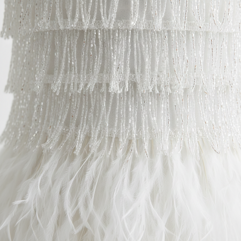 Nahaufnahme eines Federstoffs, der eine weiche, geschichtete Struktur und eine leichte Bewegung aufweist.