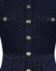 Nahaufnahme des navyblauen Strickkleids mit sichtbarer Rippenstruktur und dekorativen goldenen Knöpfen.