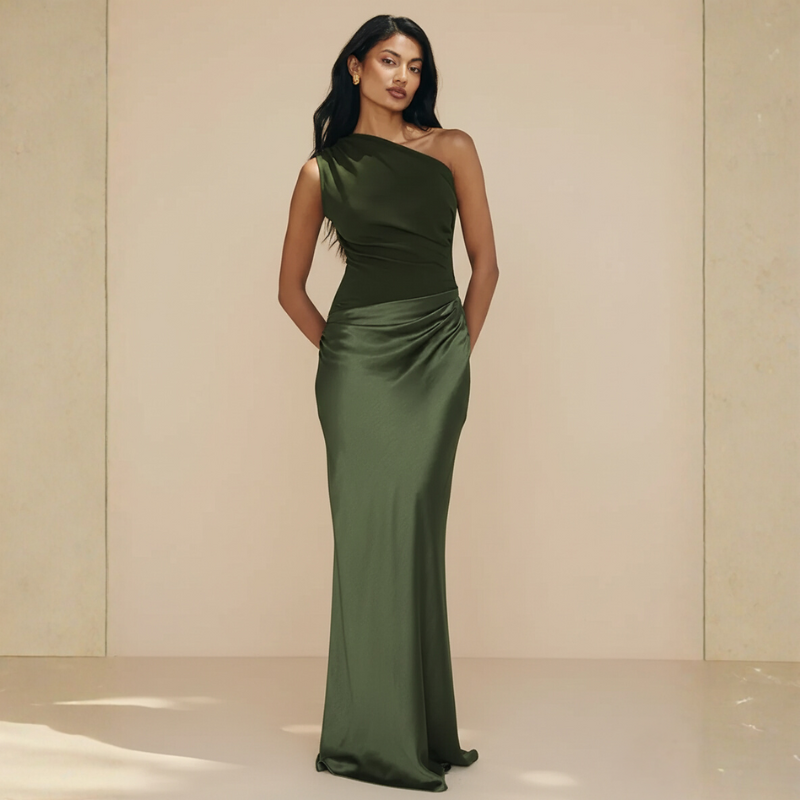 Model zeigt ein olivgrünes Abendkleid mit seitlicher Drapierung und langer Silhouette im neutralen Innenraum.