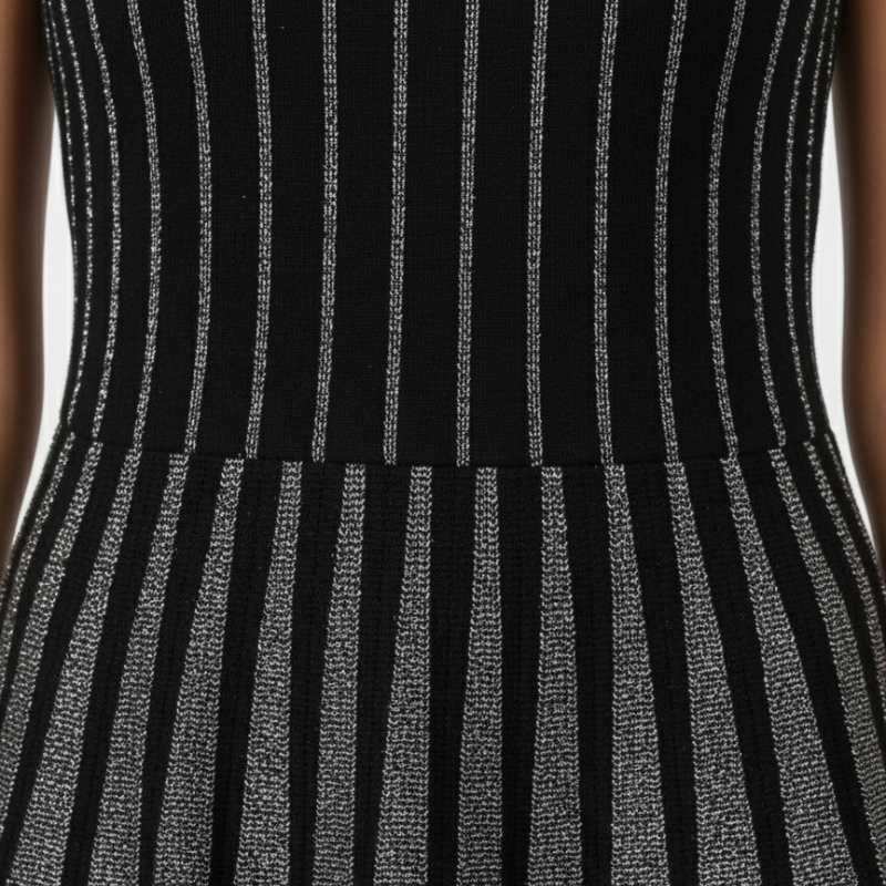 Nahaufnahme der gerippten Struktur des schwarzen Minikleids mit vertikalem Muster und hochwertiger Verarbeitung.