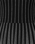 Nahaufnahme der gerippten Struktur des schwarzen Minikleids mit vertikalem Muster und hochwertiger Verarbeitung.