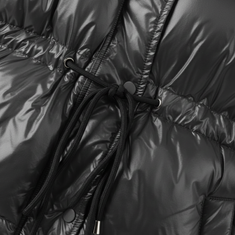 Nahaufnahme der schwarzen Steppjacke mit glänzender Oberfläche und markanter Steppstruktur.