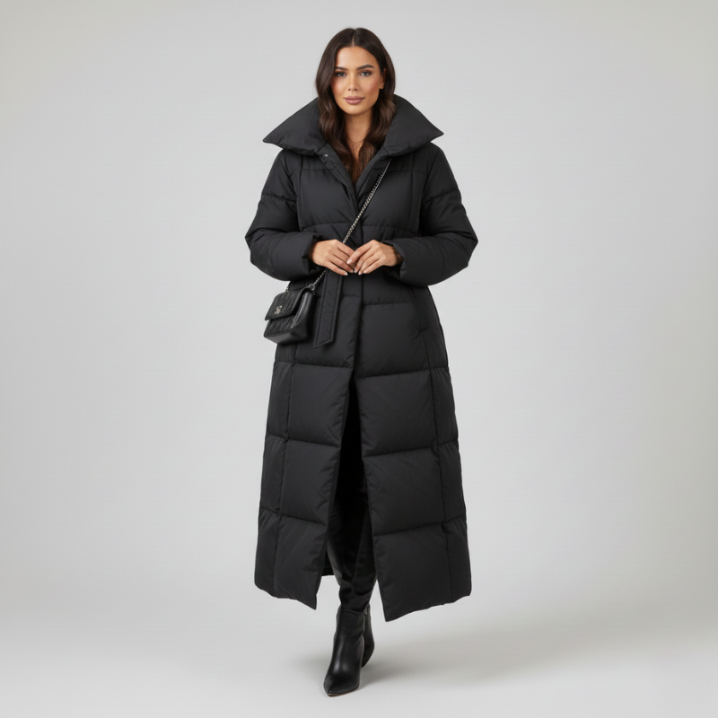 Langer schwarzer Wintermantel mit Gürtel und hohem Kragen auf einem Kleiderbügel vor hellem Hintergrund präsentiert.