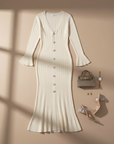 Beiges Strickkleid mit goldenen Knöpfen und V-Ausschnitt flach ausgelegt, kombiniert mit Accessoires auf hellem Untergrund.