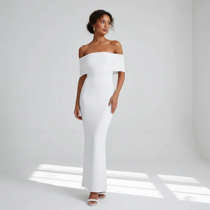 Model trägt ein weißes schulterfreies Maxikleid in hellem Studio mit natürlichem Licht