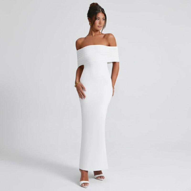 Model trägt ein weißes schulterfreies figurbetontes Maxikleid im Studio