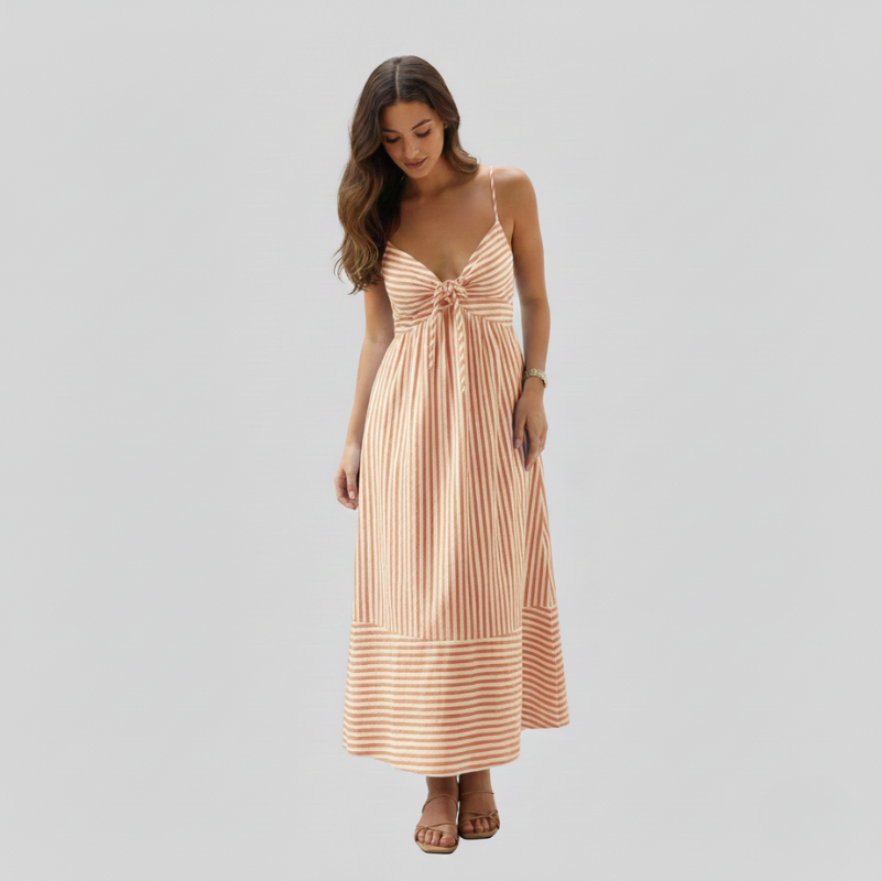 Woman wearing a peach striped sundress with a relaxed fit and summery silhouette in bright studio lighting.