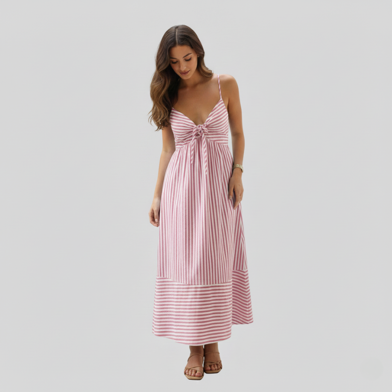 Female model in a pink striped sundress with a flowy skirt and tie-front neckline in soft studio lighting.